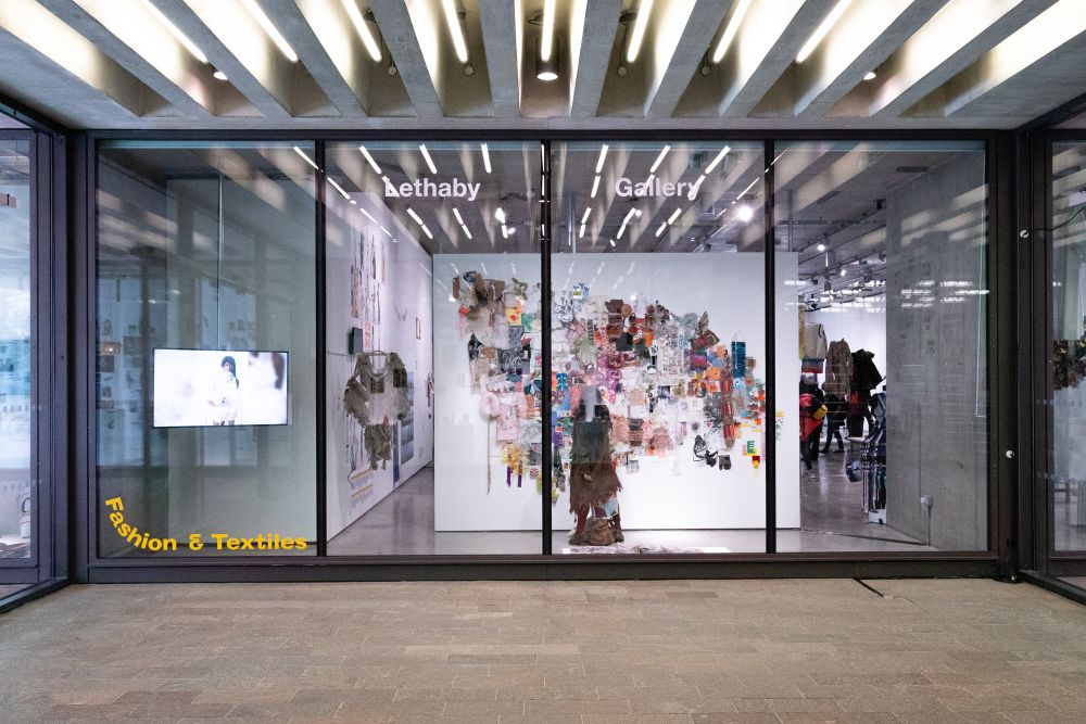 Photograph of textiles on display through as seen through a window