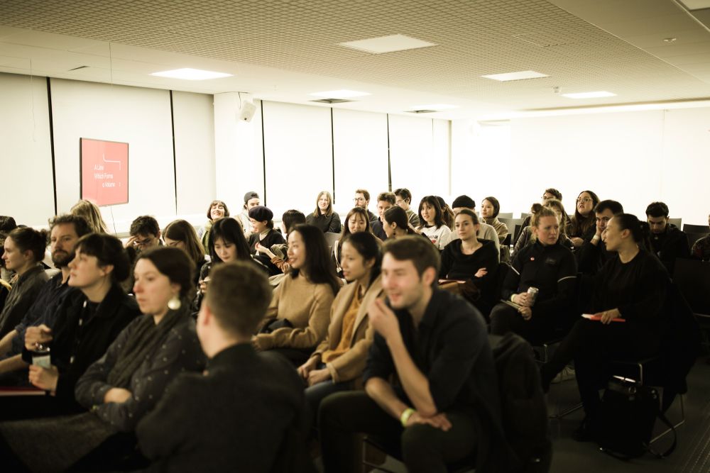 Guests seated in a lecture theatre watching presentations.