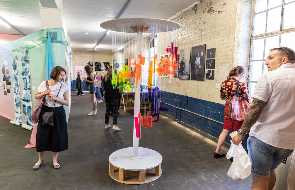 A sculture of different coloured hanging acrylic sheets inspired by Ines Enal