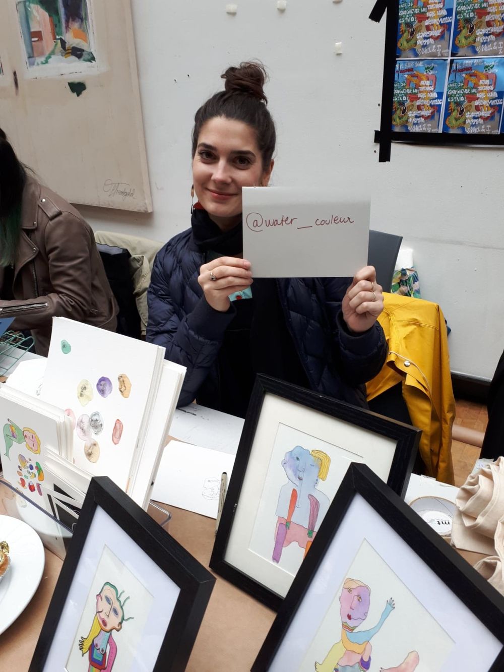 student at holiday market holdin gup a card with instagram handle written onto it