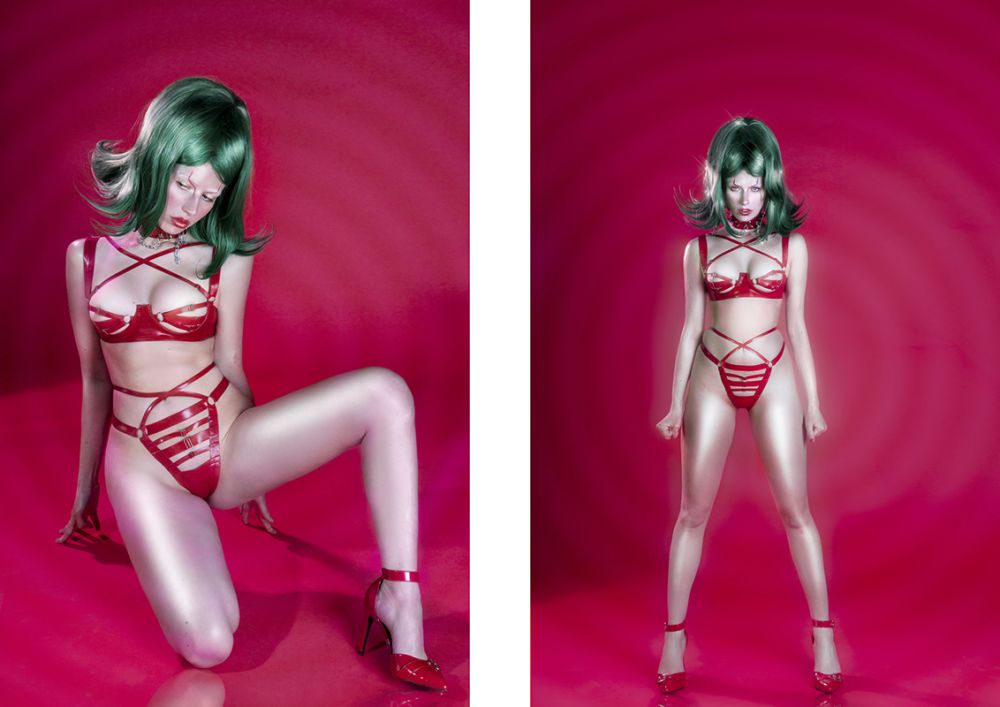 Female model standing on a pink background wearing a green wig and red lingerie