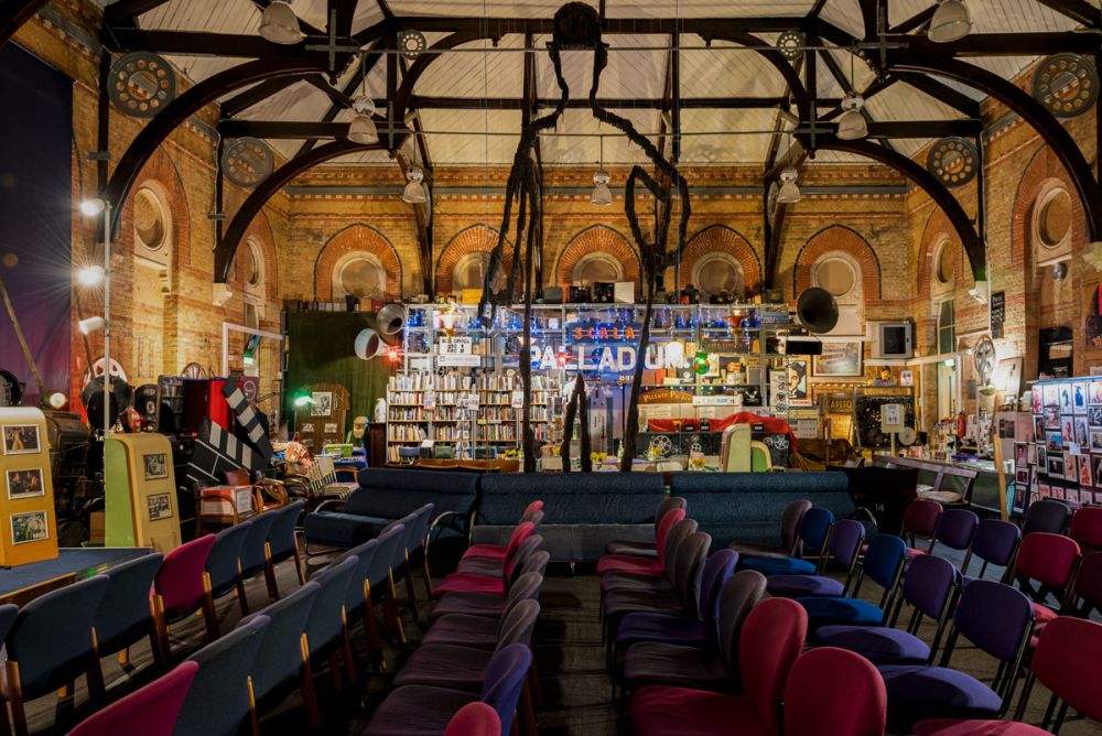 Rows of seats in front of bare brick walls of The Cinema Museum