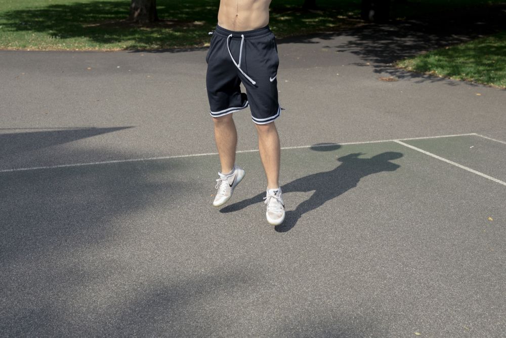 figure on tarmac wearing shorts
