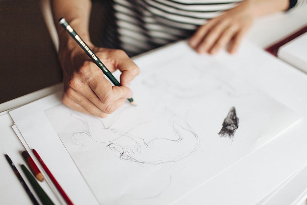 Hand resting on paper, drawing.