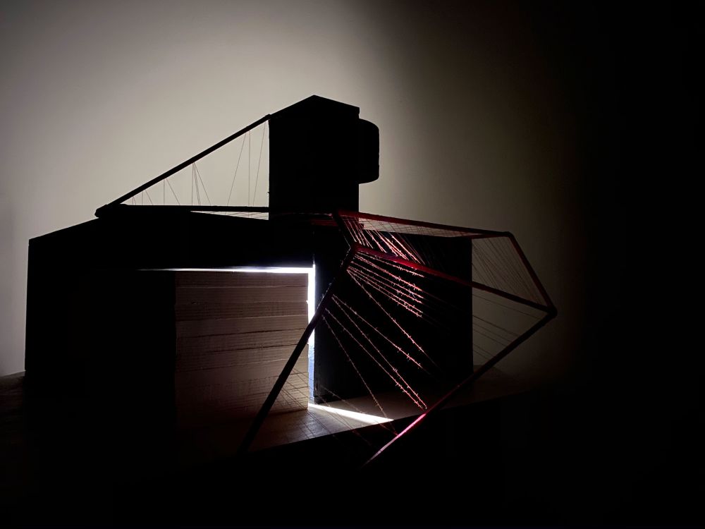 Model of structure made in card and red thread