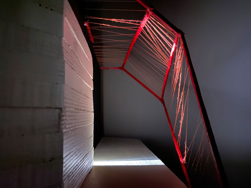 Model of structure made in card and red thread
