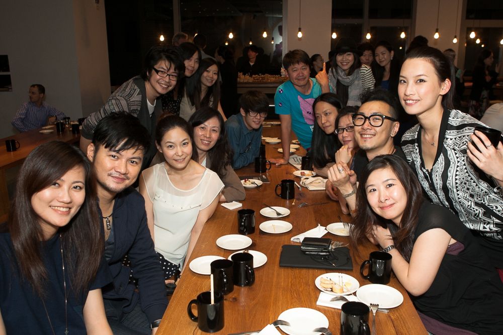 7 people sat around a table looking at the camera