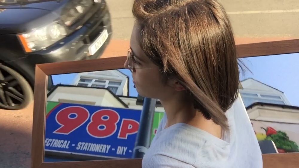 Photographs of woman carrying a mirror which is reflecting shop signs