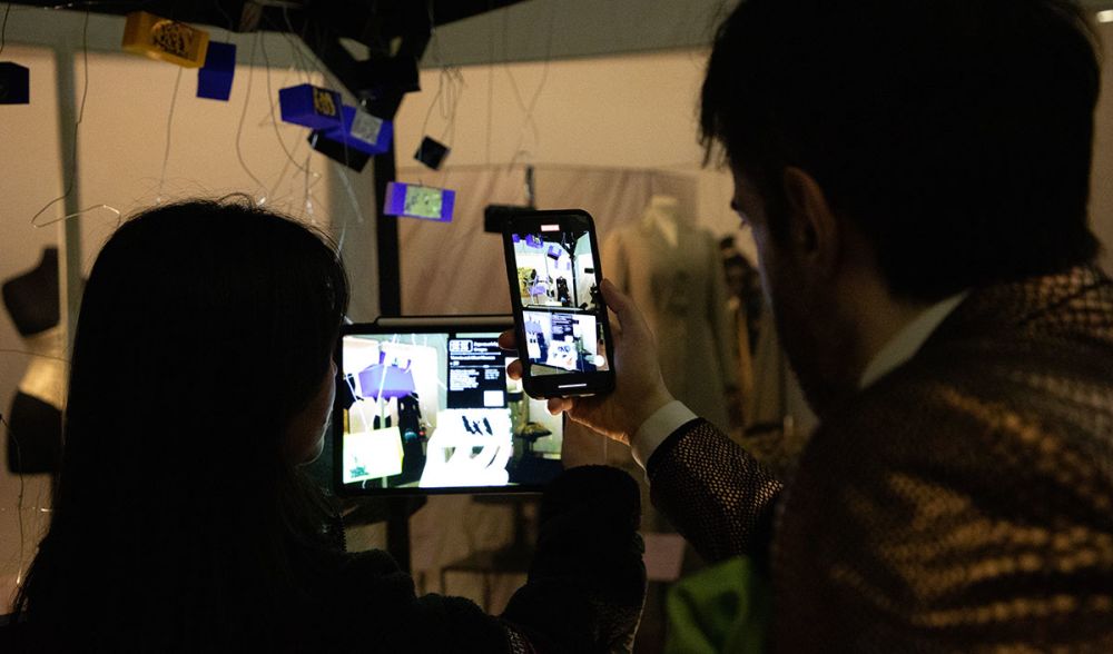 Visitors take photographs of student work.