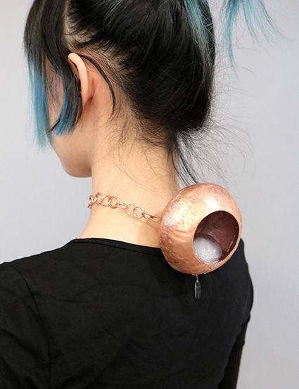 Copper vessel sitting on the back of a neck