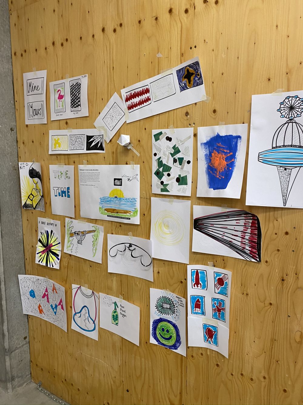 Different illustrations and drawings done on paper stuck up on the wall