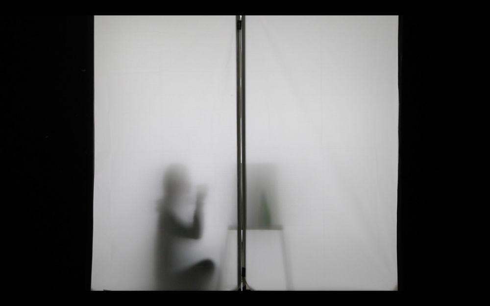 Silhouette of person sat at desk.