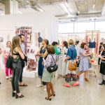 Photograph of a group of people looking at artwork on display
