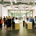 Photograph of a group of people looking at artwork on display