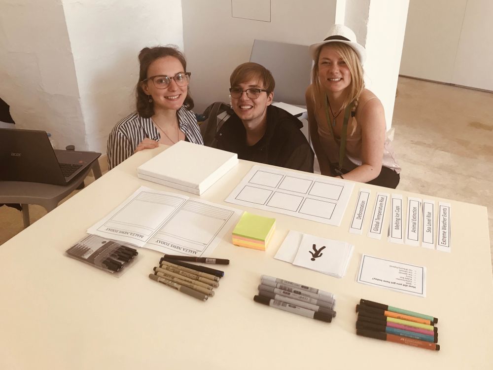 Students sitting next to table with work on as part of the project