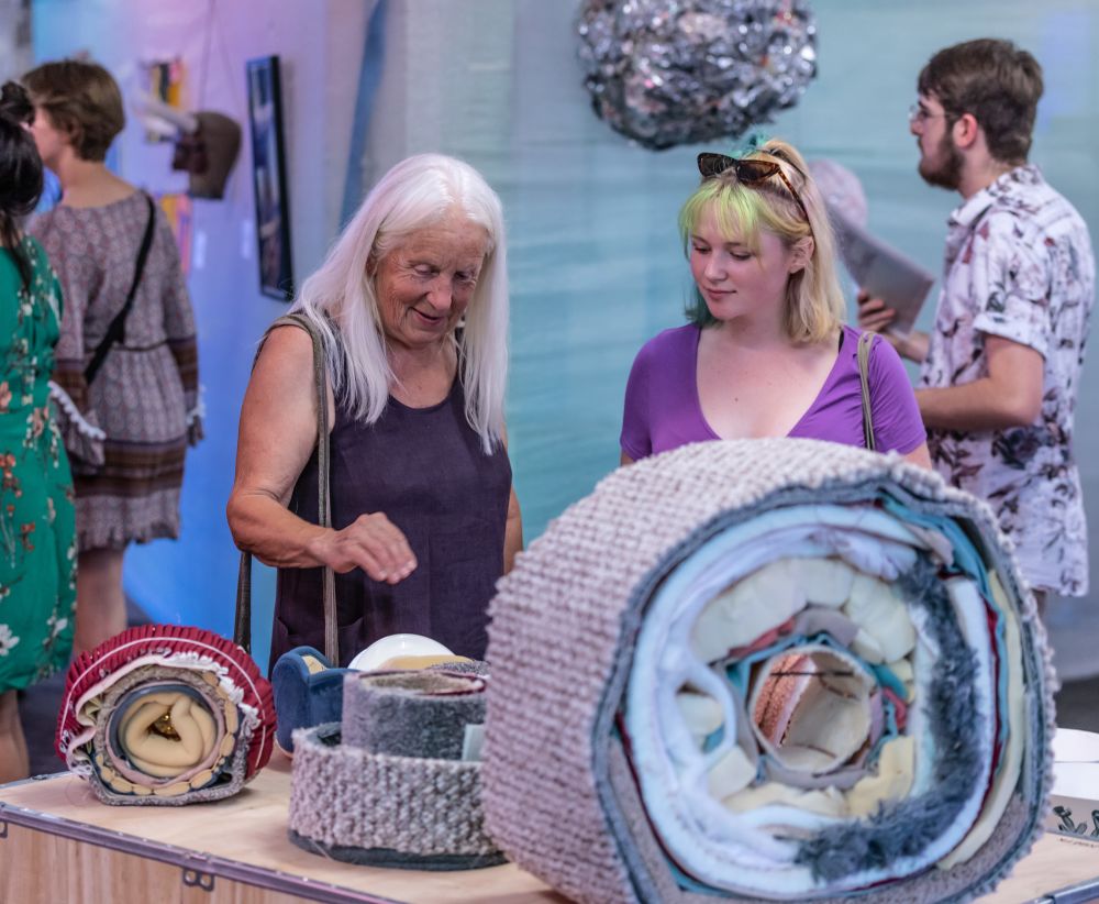 Visitors look at artwork