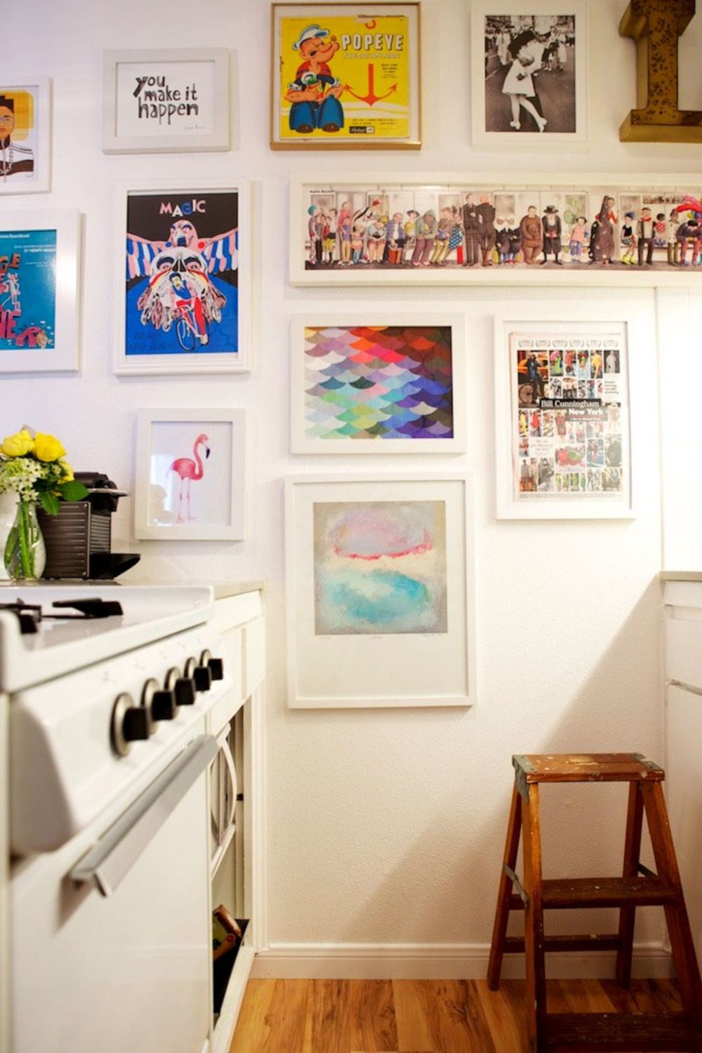 kitchen with paintings and photos hung up as though a gallery