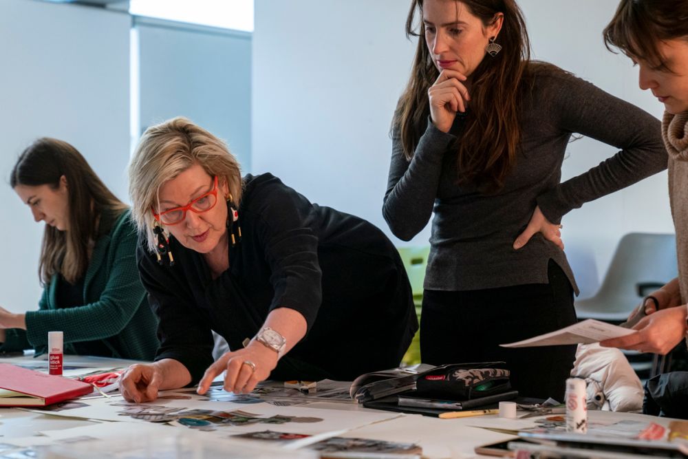 Tutor assisting students with a moodboard