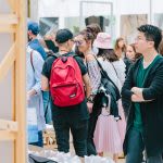 Photograph of a group of people looking at artwork on display