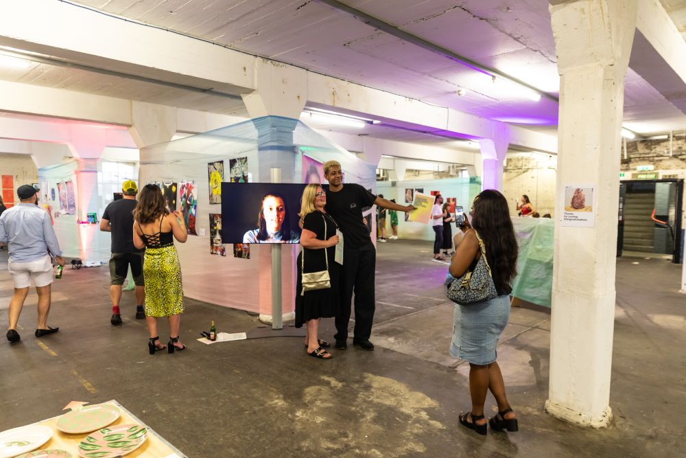 Students pose for photos with their family and friends in front of their artwork