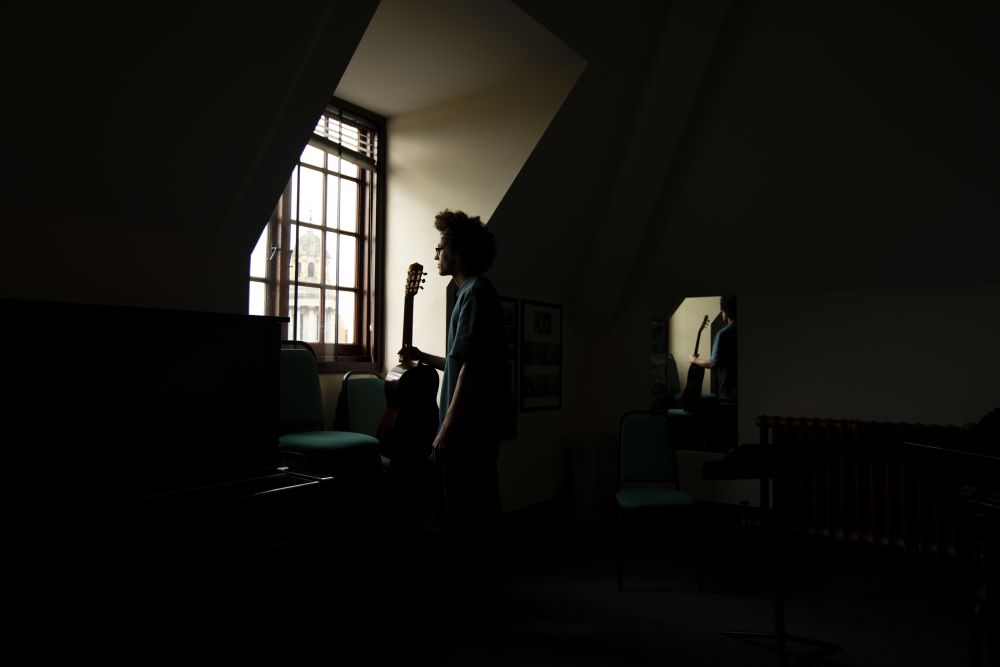 man sat by window with light coming through window