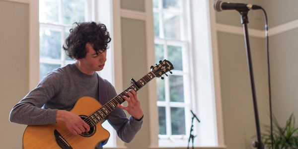 George Nash playing his acoustic guitar at the conference