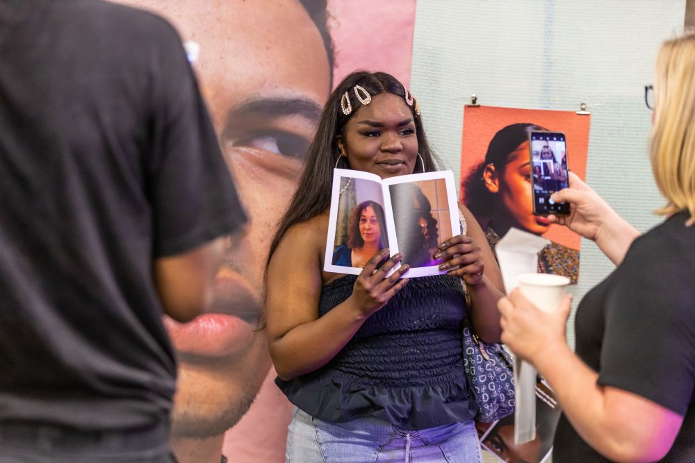 Students pose for photos with their artwork