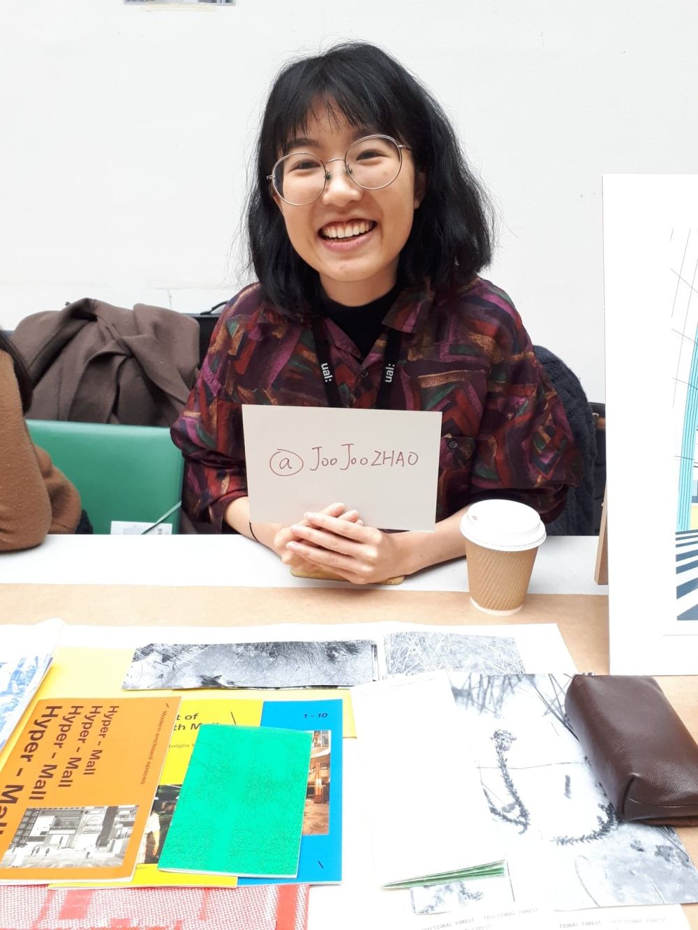 student at holiday market holdin gup a card with instagram handle written onto it