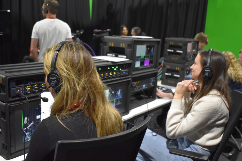 Staff with headphones behind the scenes of a TV set