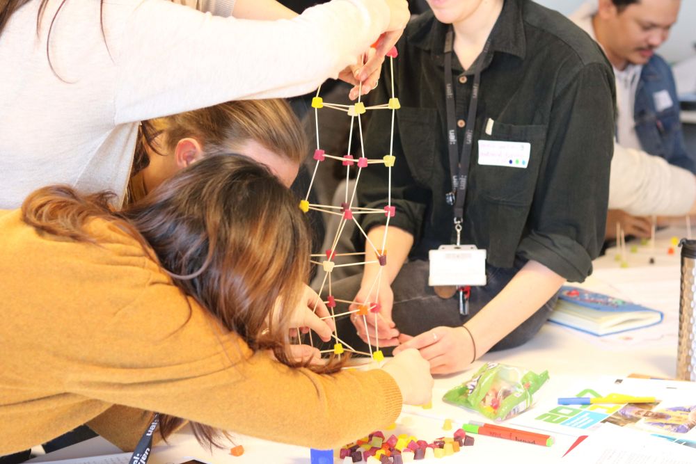 Students building tower made out of sweets and toothpicks