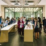 Photograph of a group of people looking at artwork on display