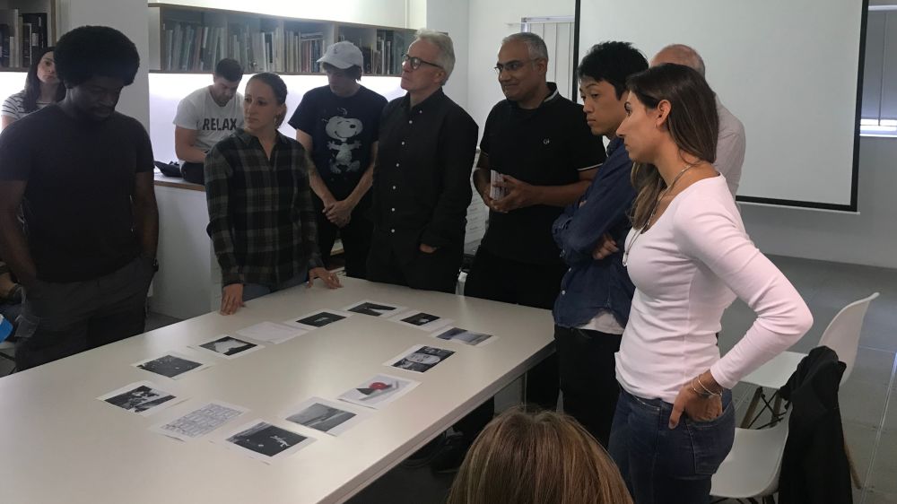 people standing around a table with images on it