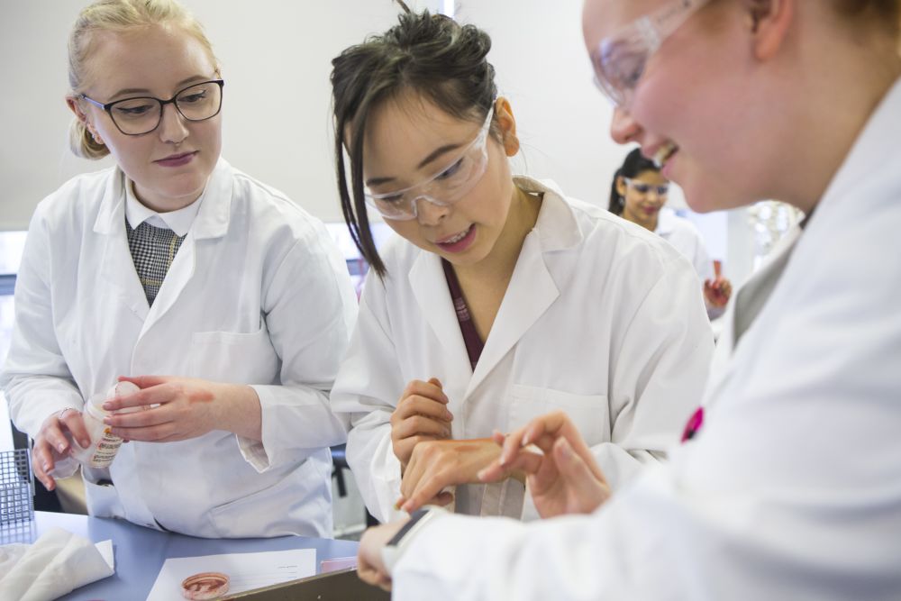 Three students in lab coats