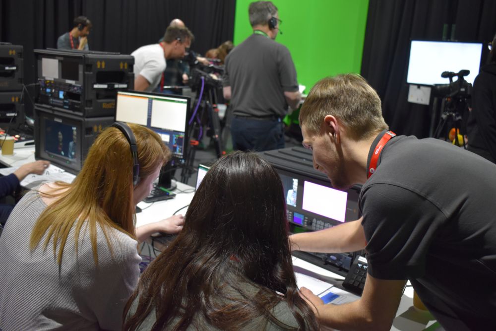 Staff with headphones behind the scenes of a TV set