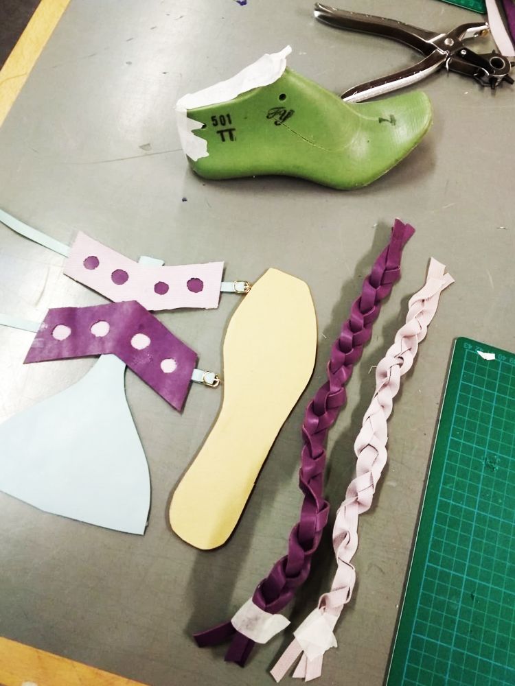 Last, materials hole punch and shoe components laid out on a table ready to be assembled.