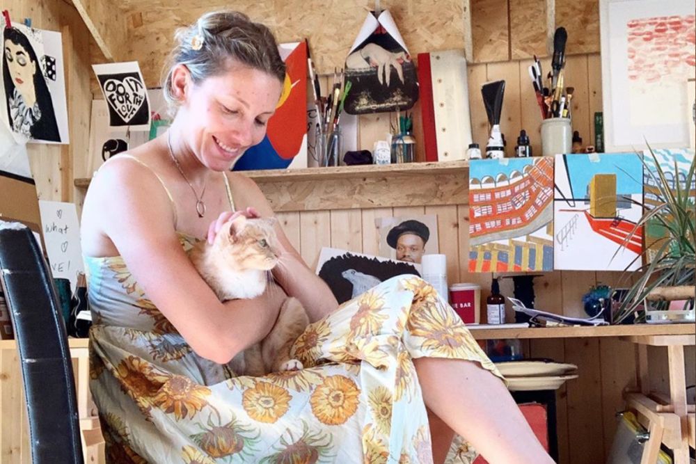 Erin and her cat in her studio.