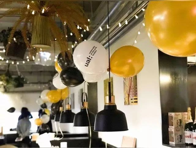 Balloons with 'UAL: University of the Arts London' logo on, tied to a light 