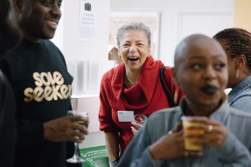 Woman laughing to camera, other people stood around