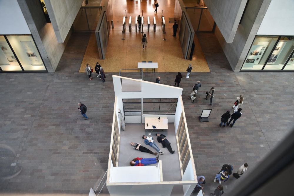 Replica structure of room seen from above with people lying on its floor
