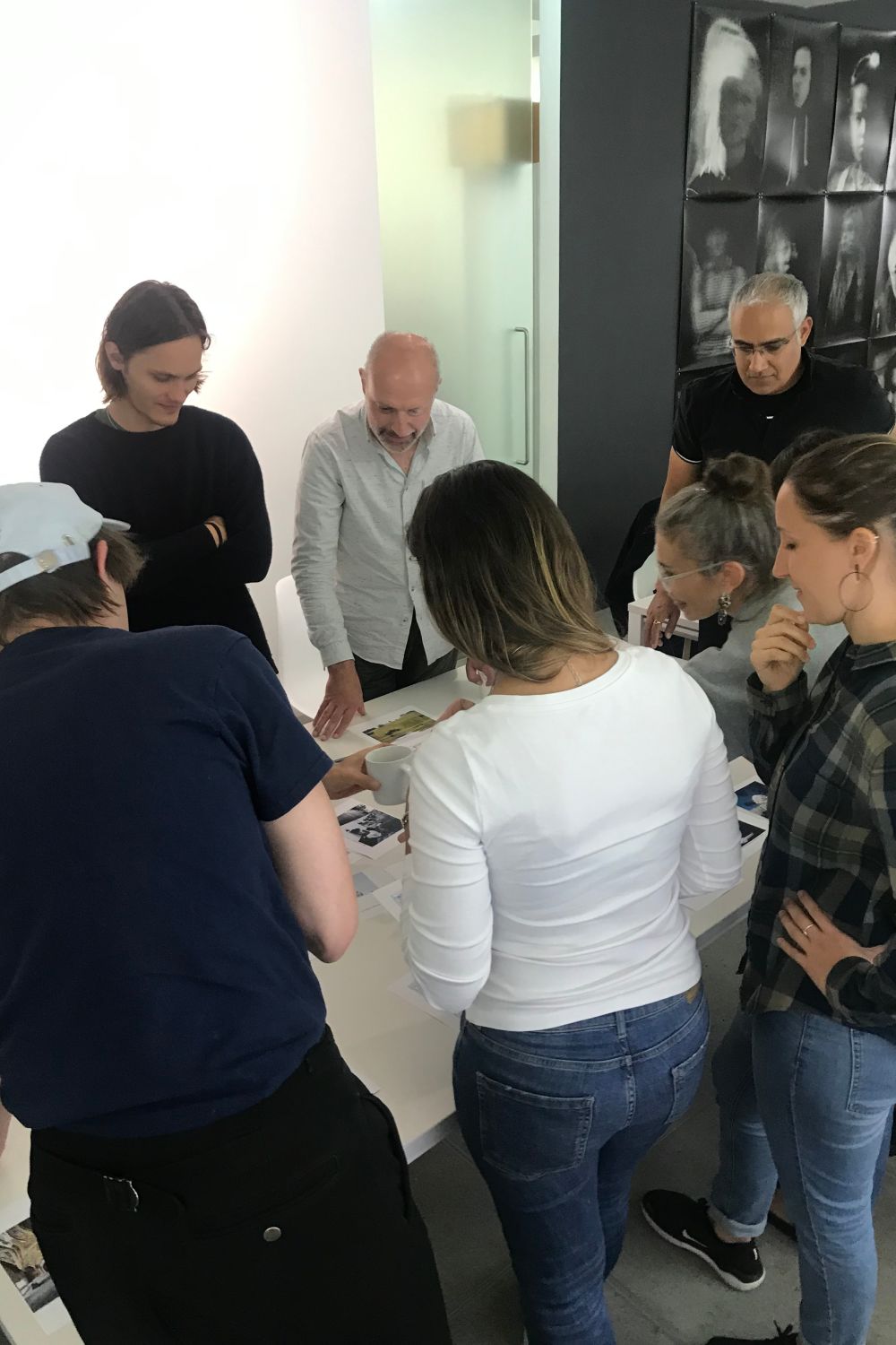 people standing around a table with images on it