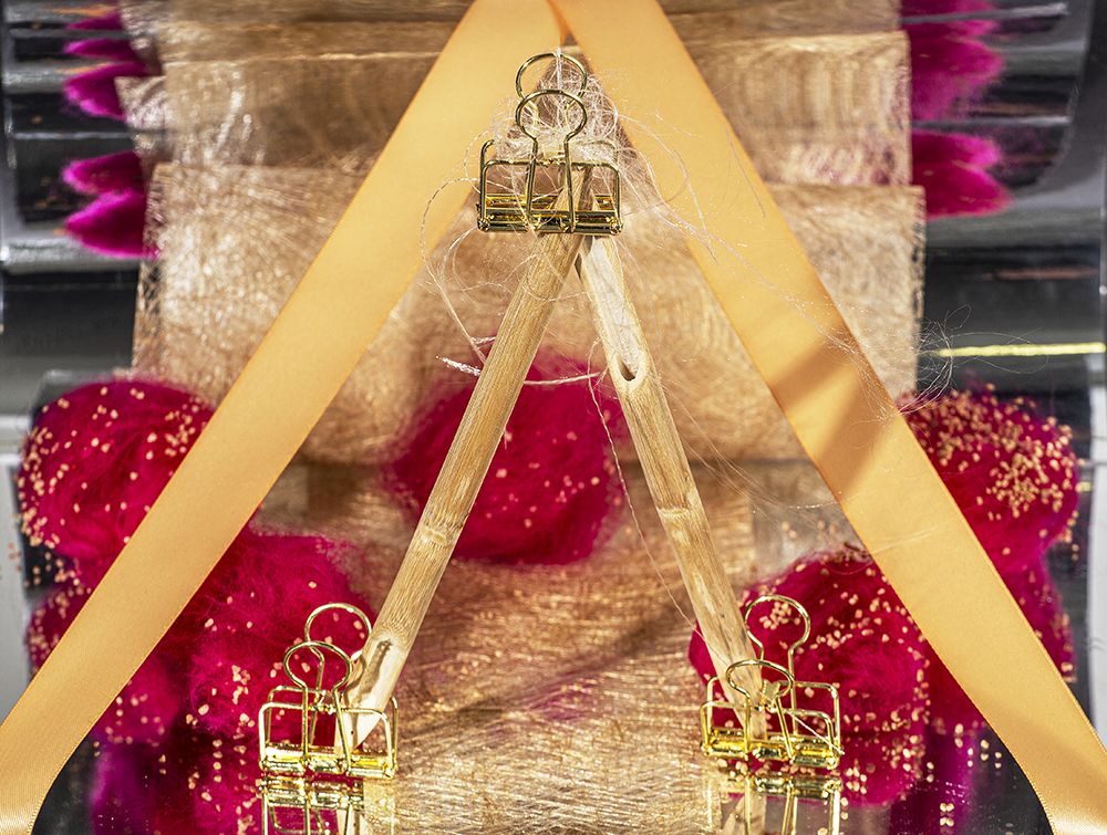 Work by Visual Merchandising - Interiors students, taken by Sarah Manning. Yellow and gold bands weighed down by gold clips forming 2 triangles.