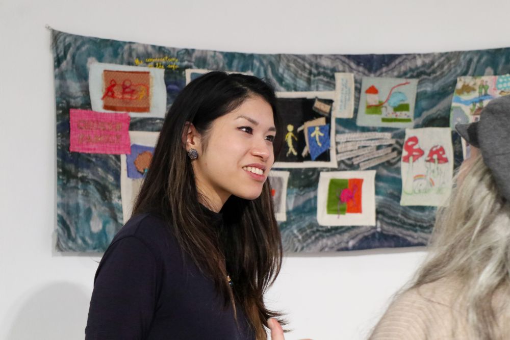 Artists in front of her artwork