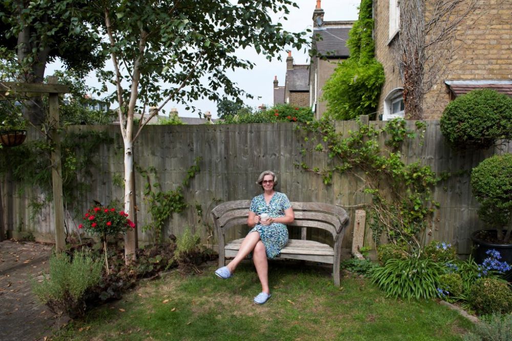 a woman sat on a bench in a garden