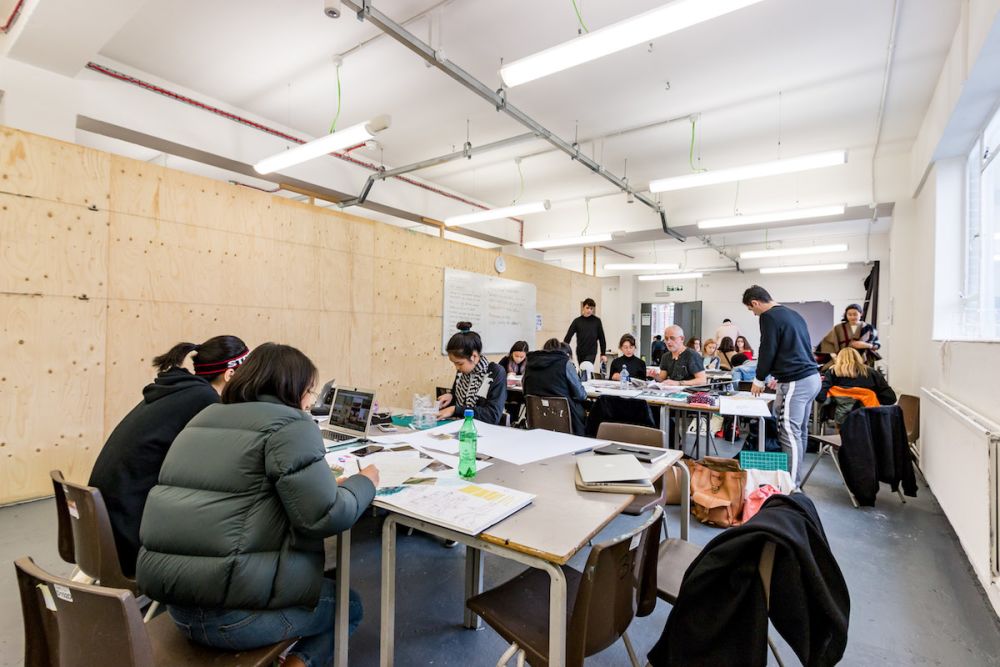 Students working at a desk inside Central Saint Martins' Archway campus
