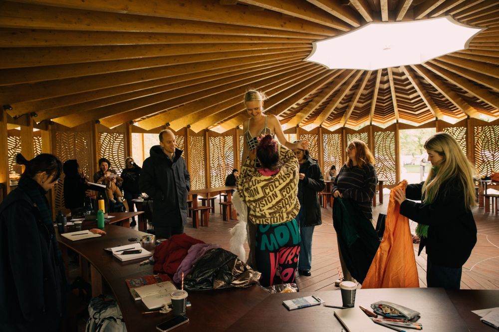 Artists draping materials over the model
