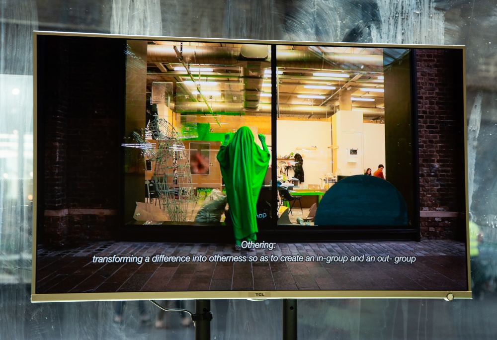 Image of screen showing film of person wrapped in green material