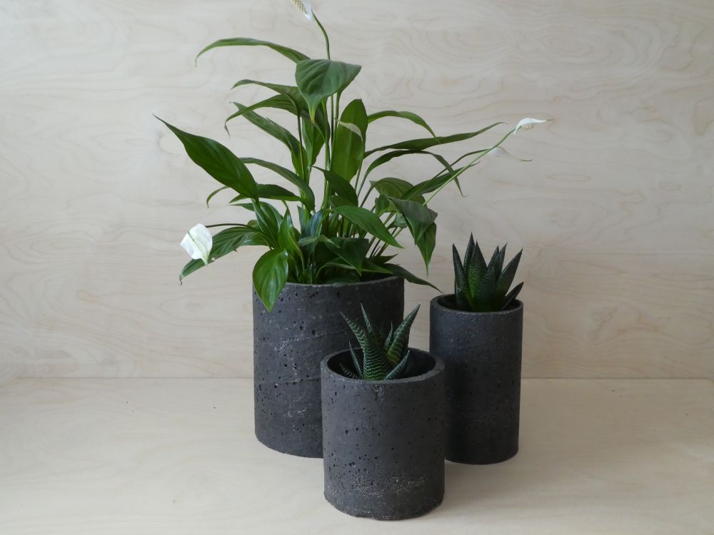 Three different sized, black plant pots