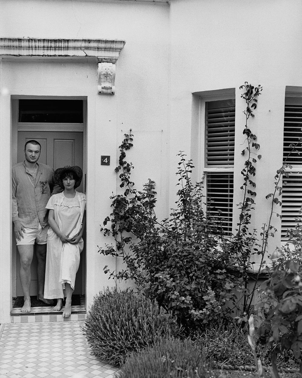 black and white photo of famioly standing on the doorstep of their home
