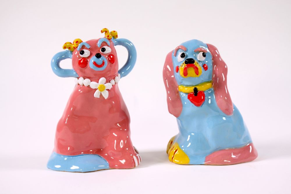 Two ceramic dogs in pink and blue