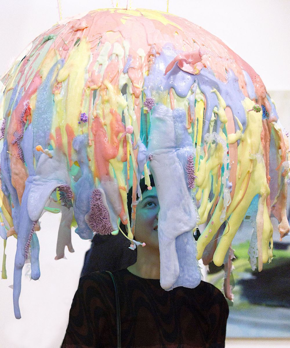 Large colourful liquid like sculpture on head of a person
